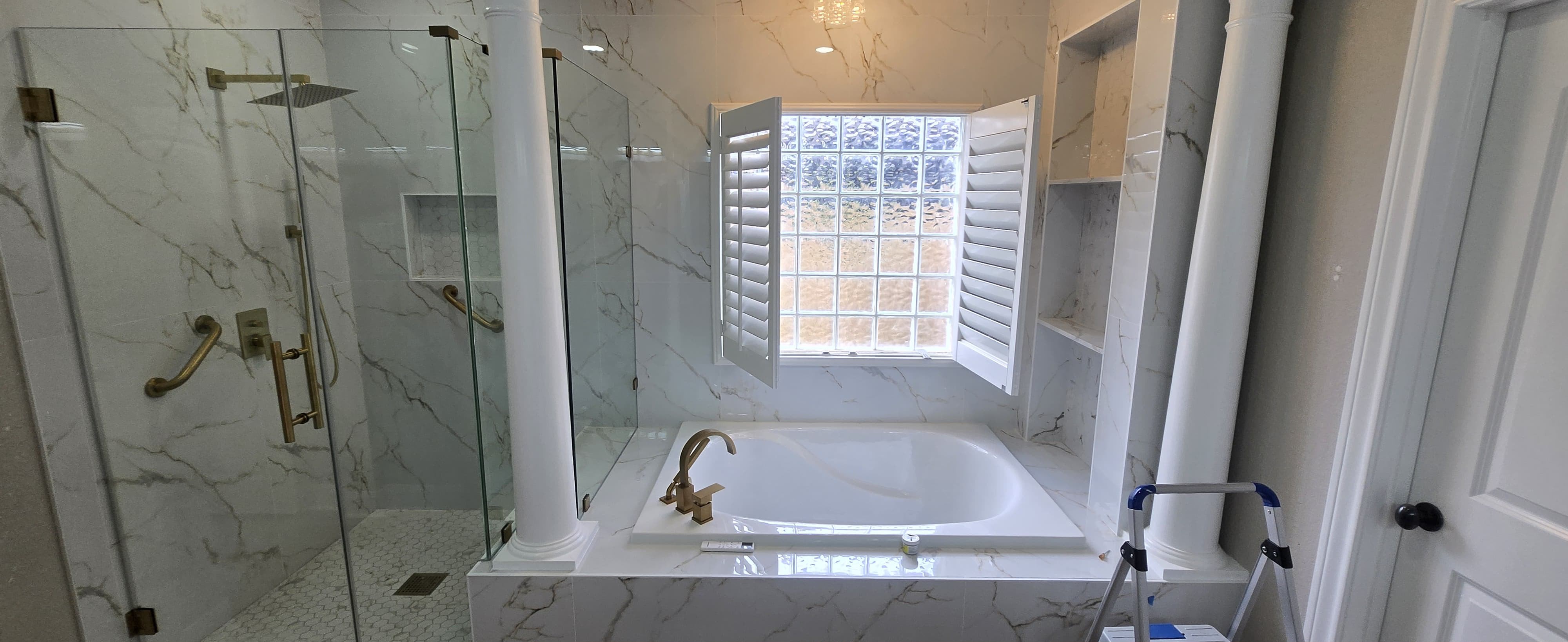 Luxury master bathroom with marble tile, glass shower and soaking tub