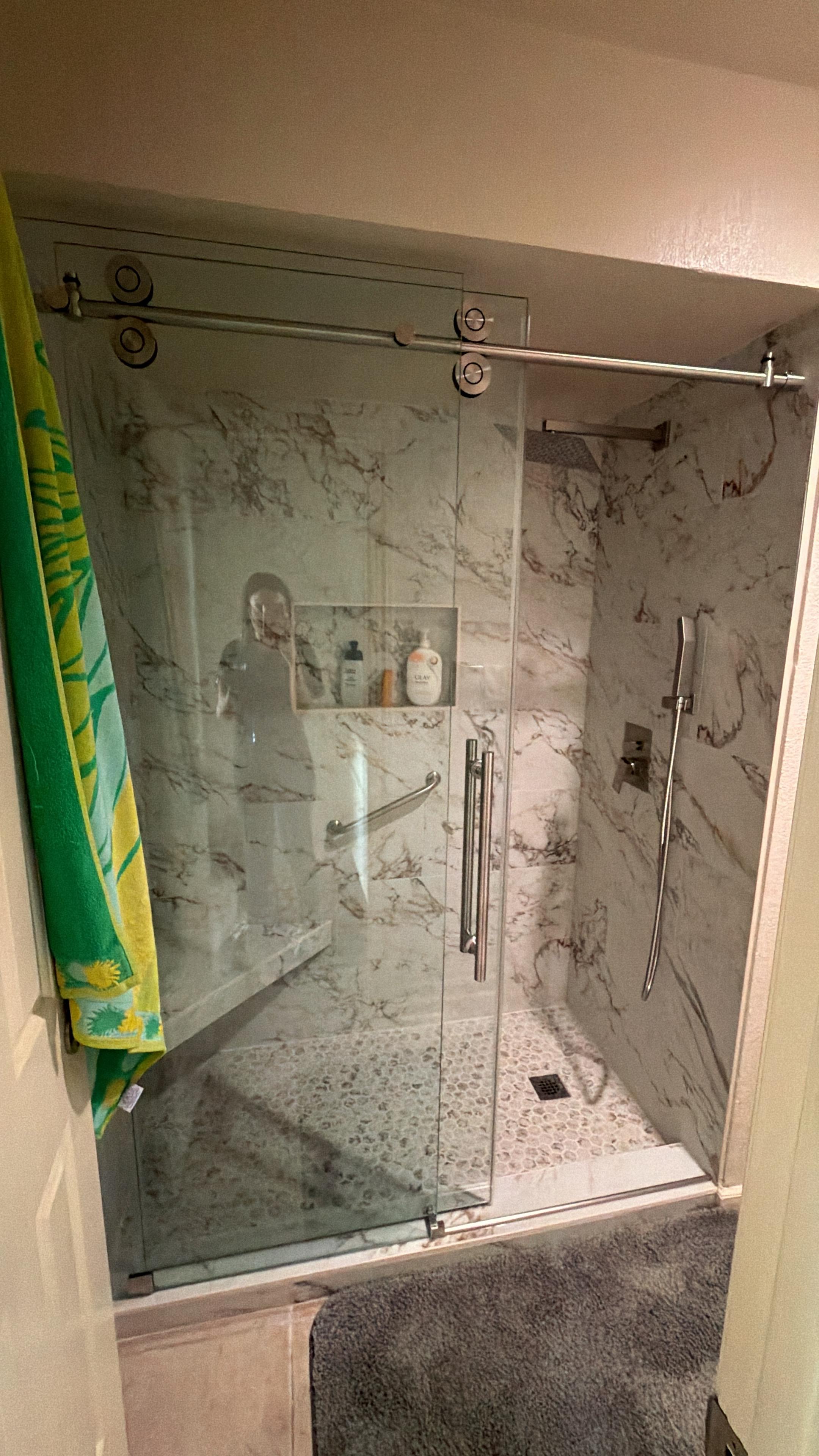 Custom marble walk-in shower with pebble tile floor